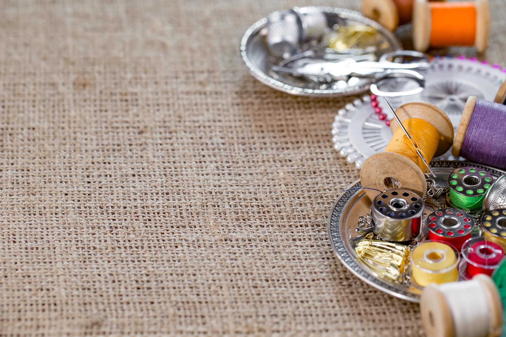 atelier table with threads, needles and embroidered sample